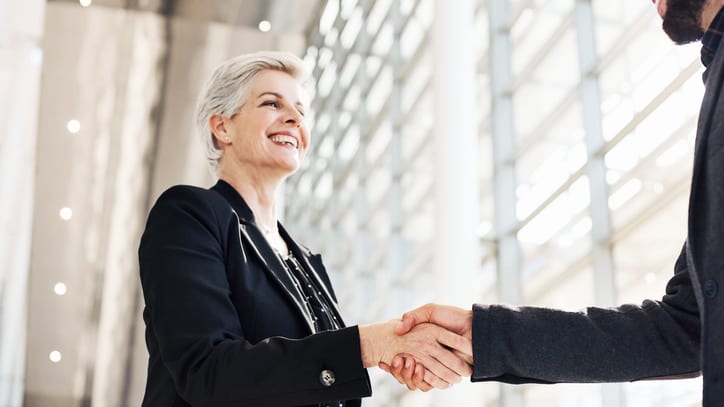 Two business people shaking hands in an office.