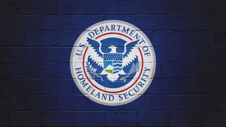 The u s department of homeland security logo on a brick wall.