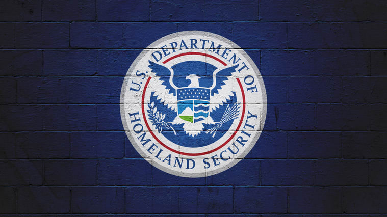 The u s department of homeland security logo on a brick wall.