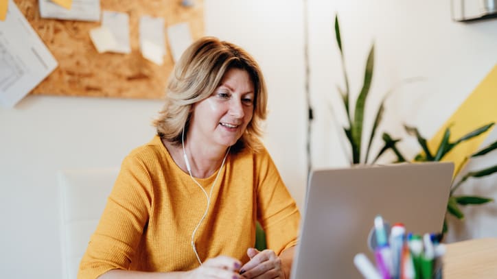 A woman sitting at a desk using a laptop.