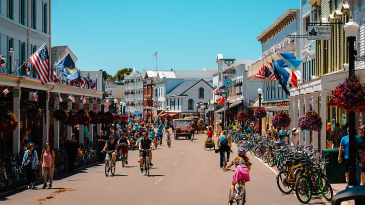 People are riding bikes down a street in a small town.