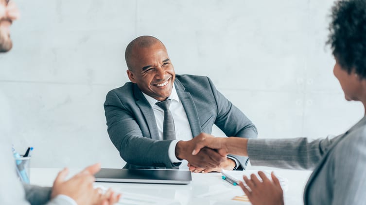 Two business people shaking hands during a meeting.