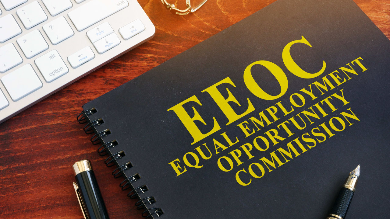 A notebook with the words eeoc on it next to a keyboard.