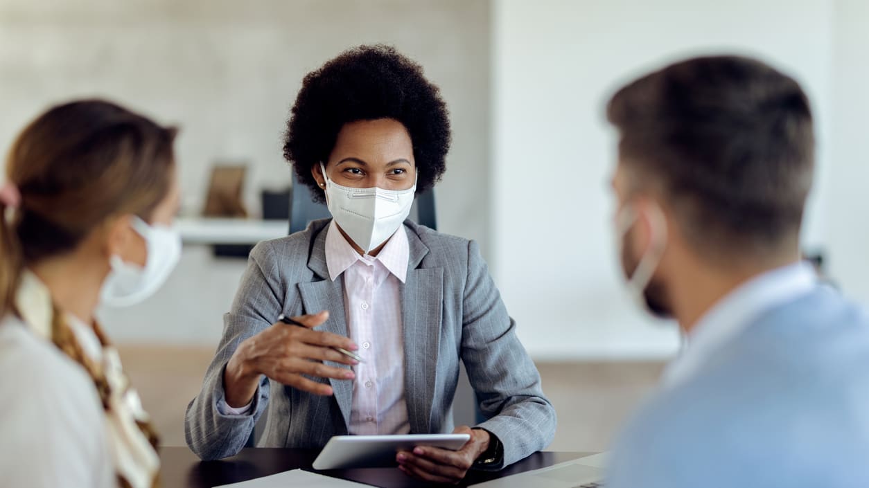 A group of business people wearing face masks at a meeting.