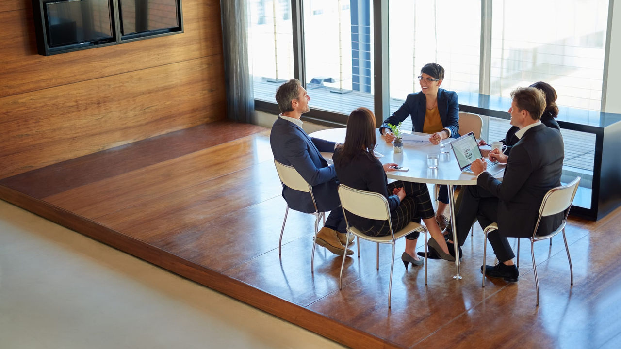 A group of people sitting around a table in a conference room.