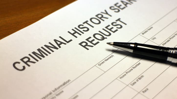 A criminal history search request form on top of a pen.