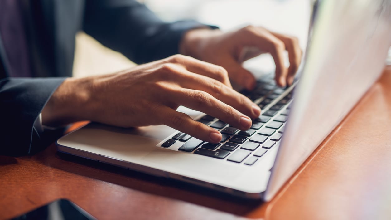 A businessman typing on a laptop computer.