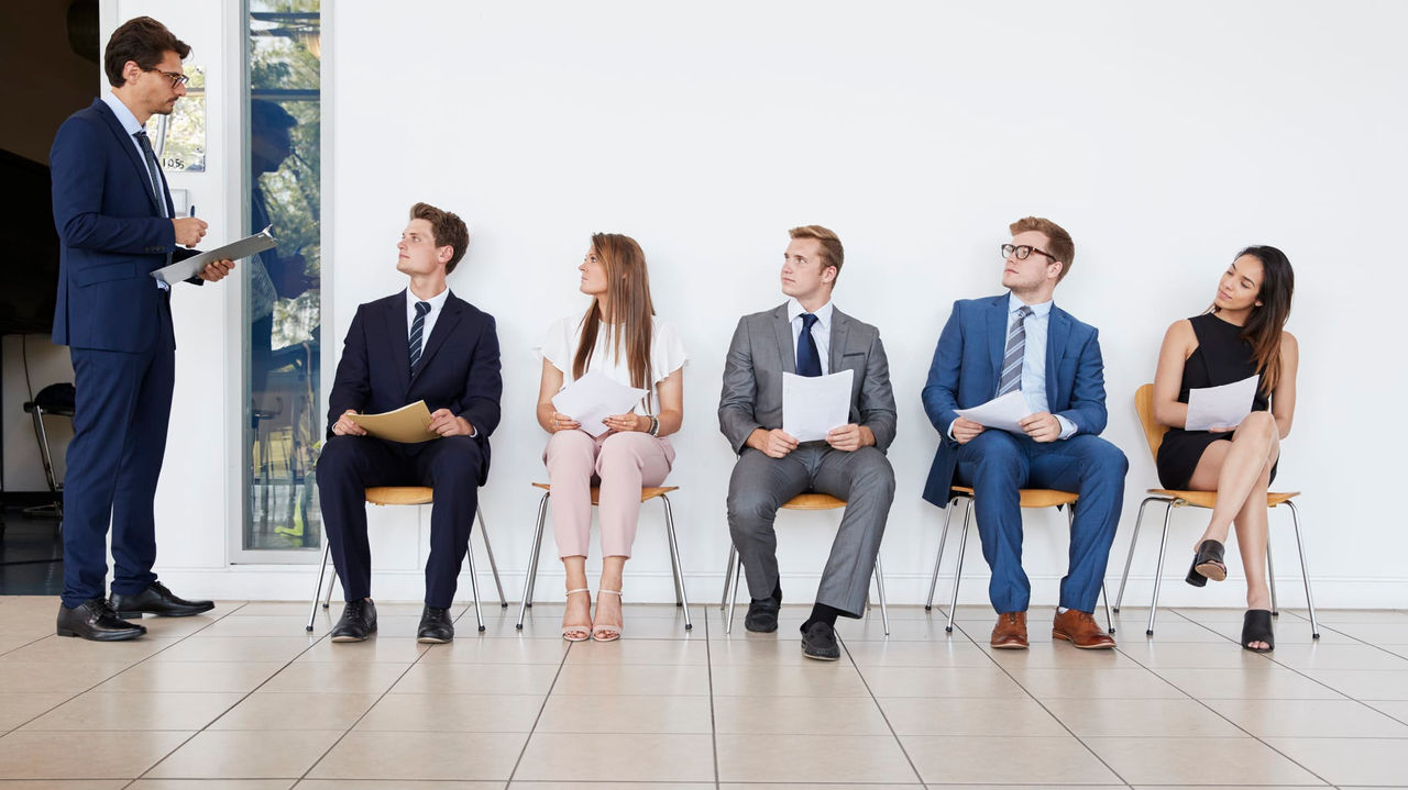 A group of business people sitting in a waiting room.