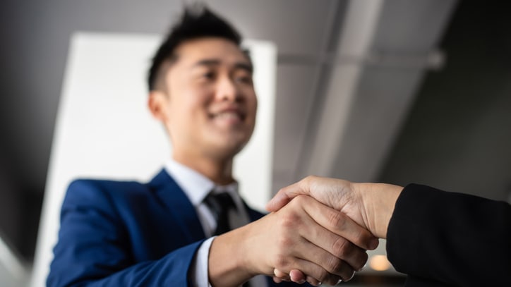 Two business people shaking hands in an office.