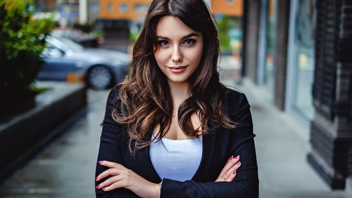 A young woman in a business suit posing for a photo.
