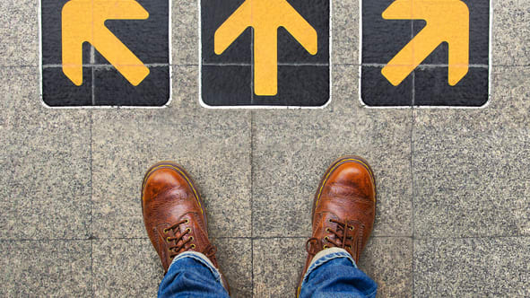 A person's feet standing on a tile floor with arrows pointing in different directions.