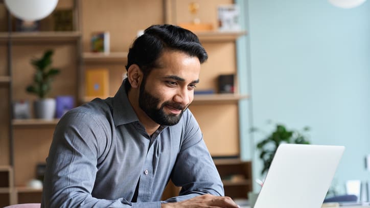 A man working on a laptop in an office.