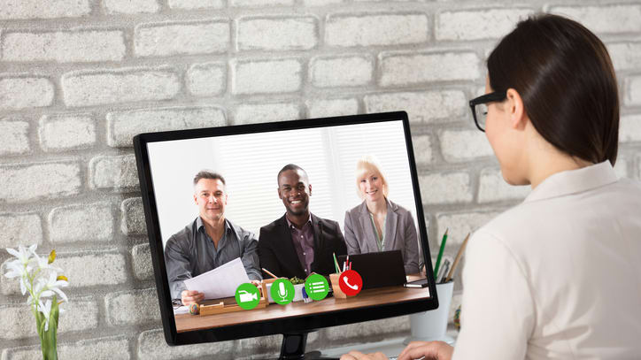 A woman is using a computer to make a video call.