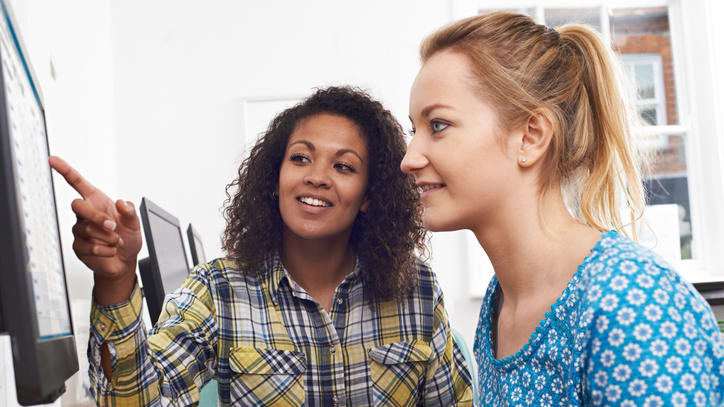 Two women looking at a computer screen.