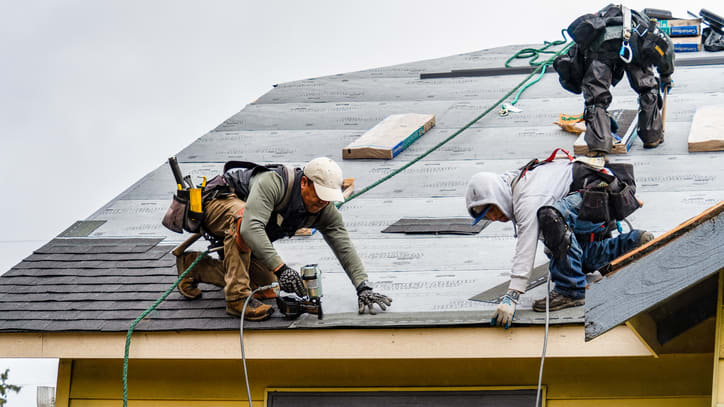A group of men working on a roof.