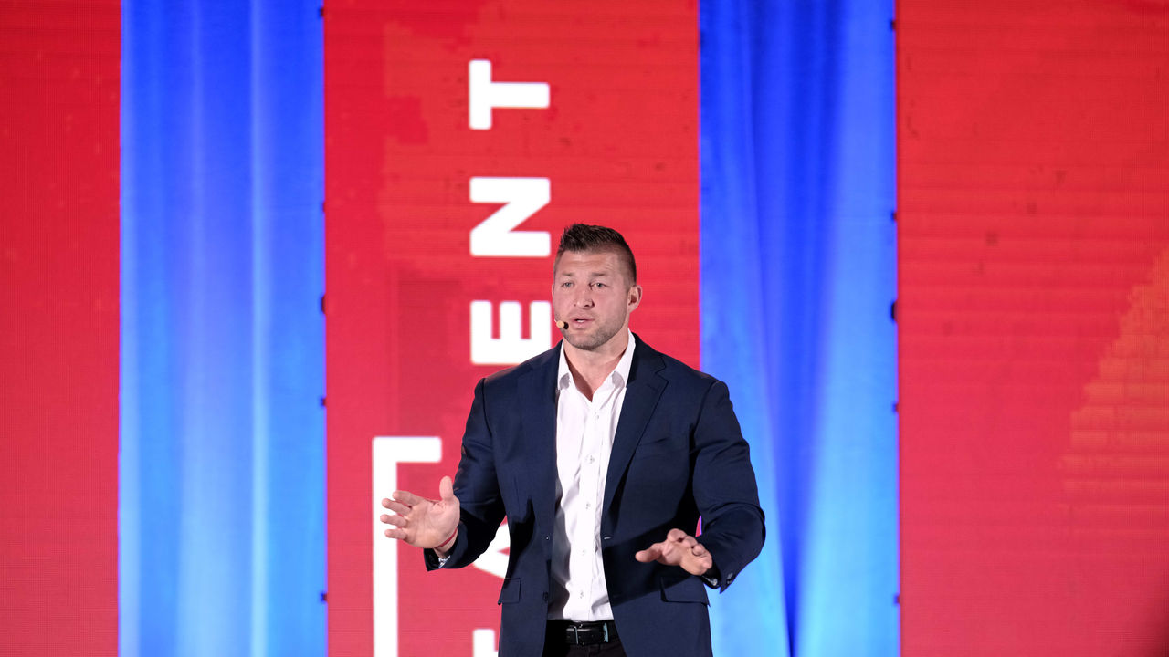 A man is speaking on stage at an event.