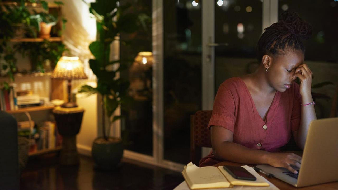 A woman working on her laptop at night.