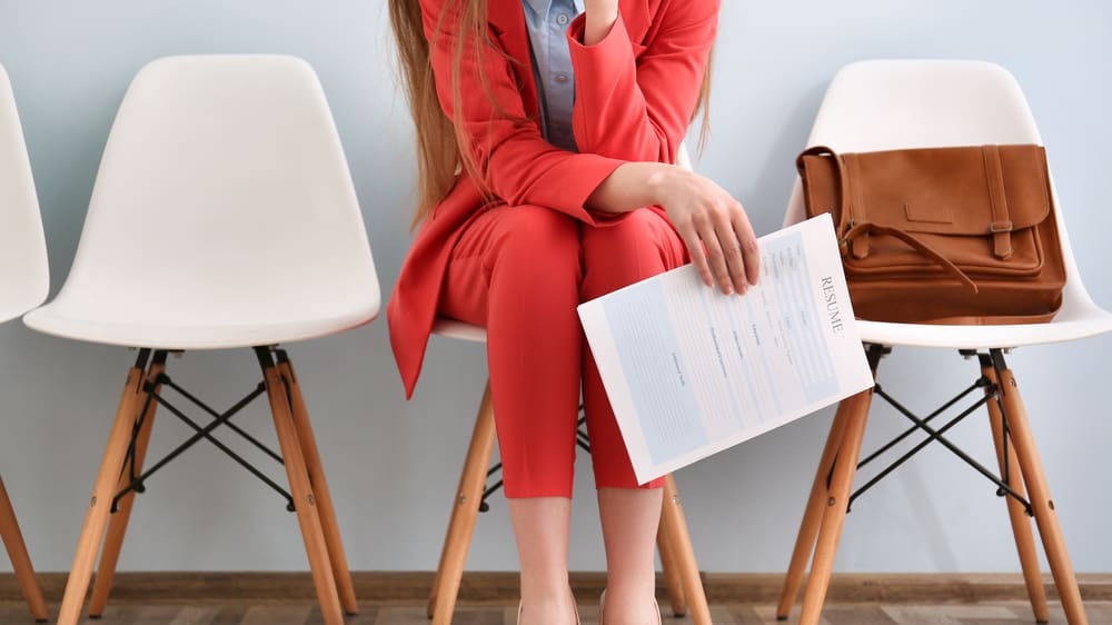 A woman sitting on a chair in front of a group of chairs.