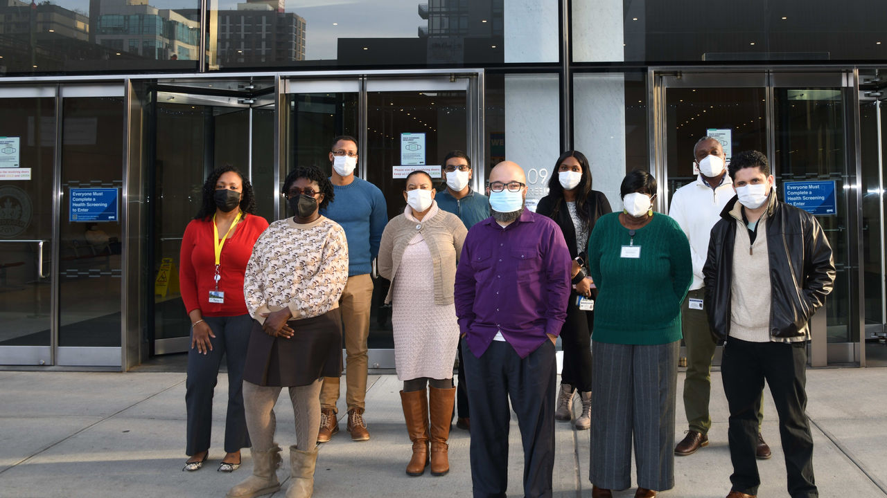 A group of people wearing face masks in front of the nyc department of health.