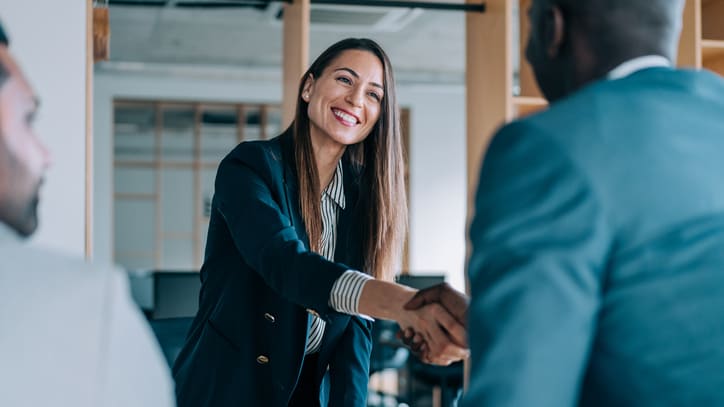 Two business people shaking hands in an office.