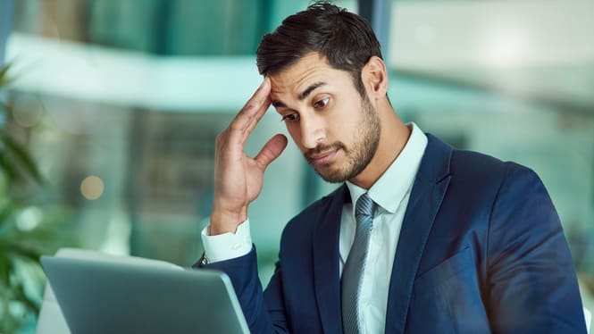 A businessman working on a laptop in an office.