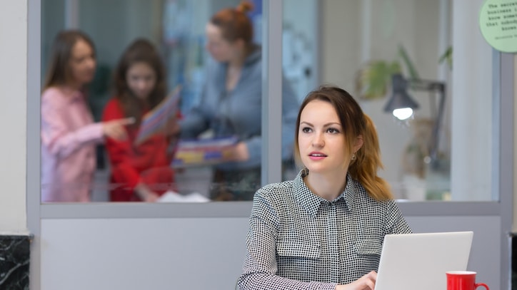 A woman sitting at a desk with a laptop in front of her.