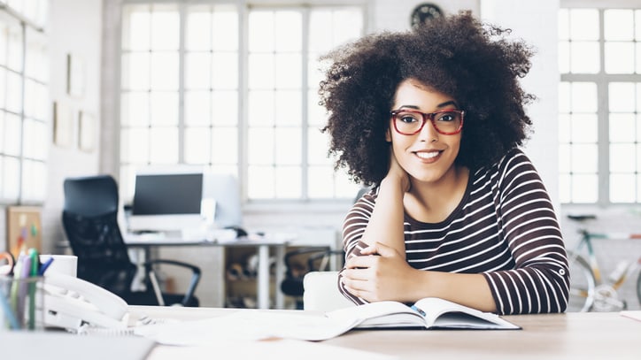 A young woman sitting at a desk in an office.