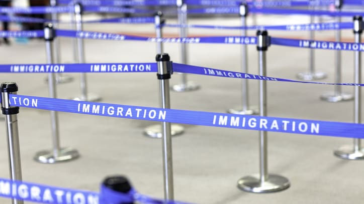 A line of blue tape with the word immigration written on it.