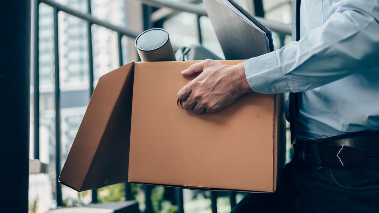 A businessman carrying a cardboard box.