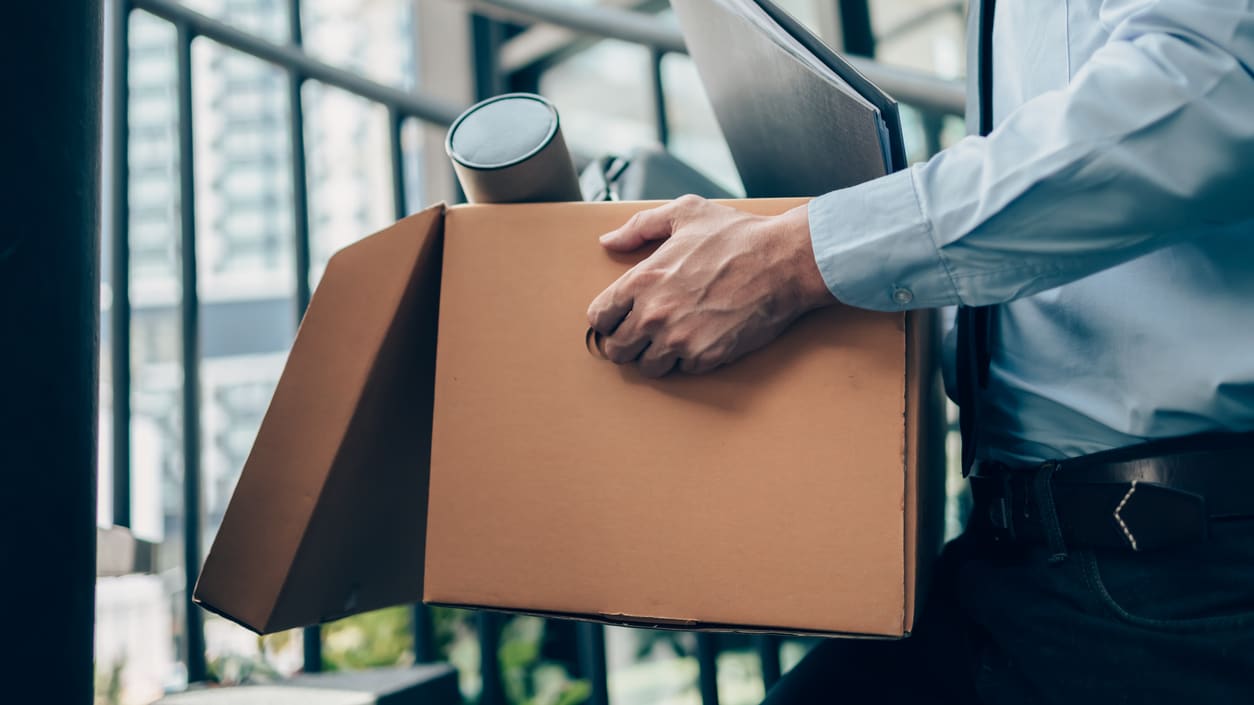 A businessman carrying a cardboard box.