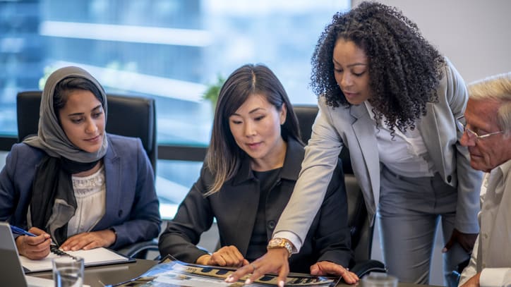 A group of business people looking at a document in a conference room.