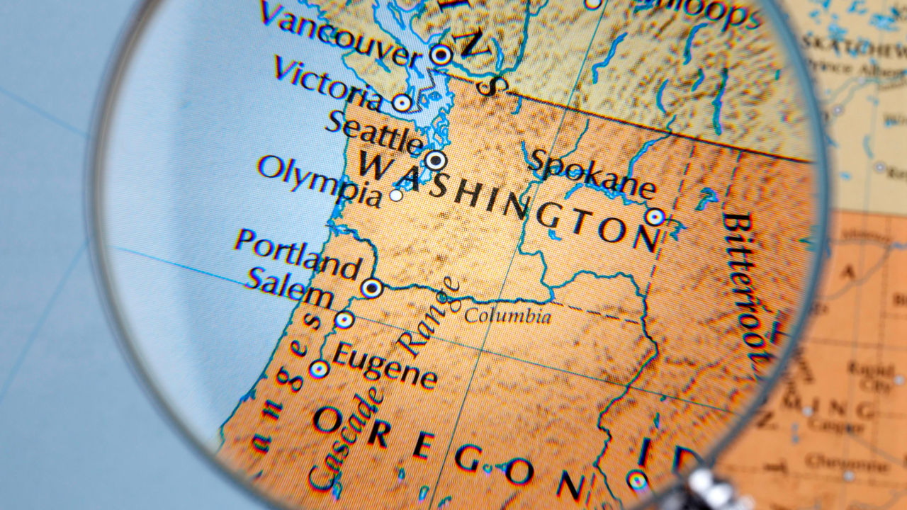 A magnifying glass is placed over a map of washington.