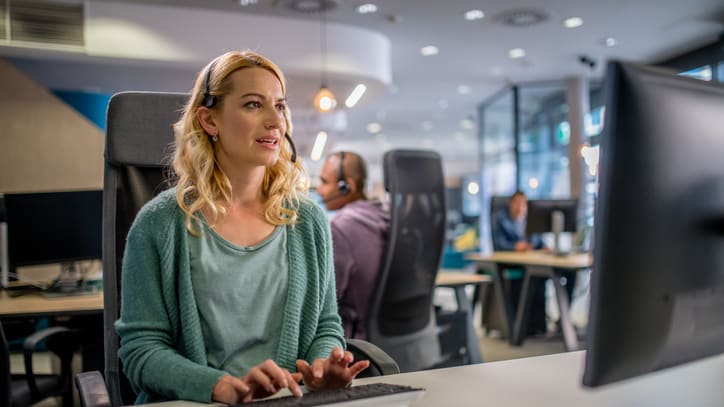 A woman working at a computer in an office.