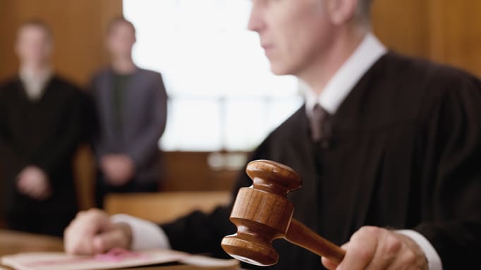 A judge hitting a gavel on a wooden table.