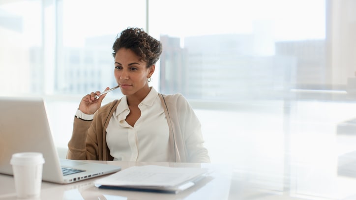 A woman sitting at a desk with a laptop in front of her.