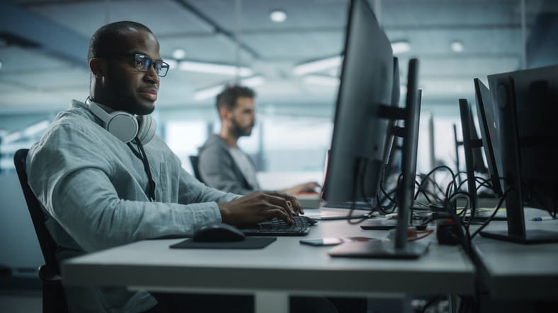 Two men working on computers in an office.