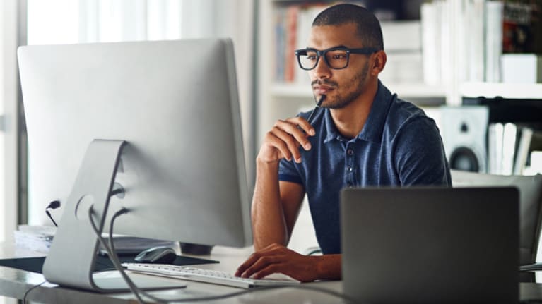 A man sitting in front of a computer screen.