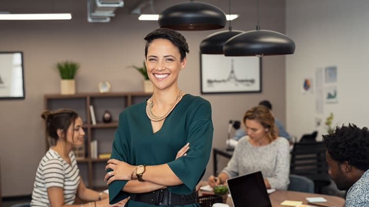 A woman standing in front of a group of people in an office.