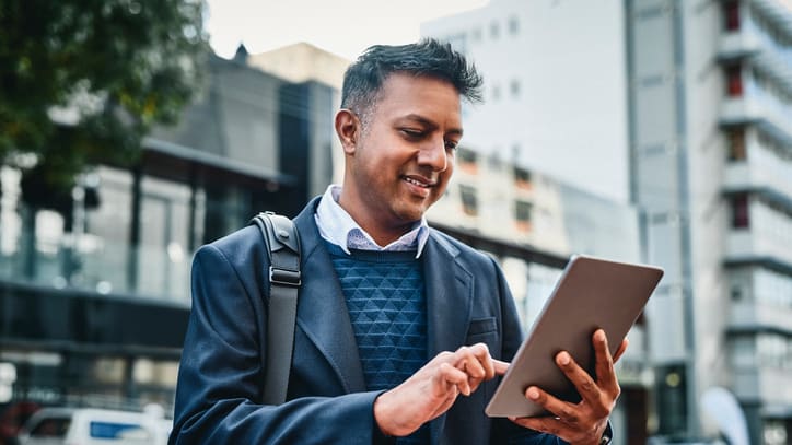 A businessman using a tablet in the city.