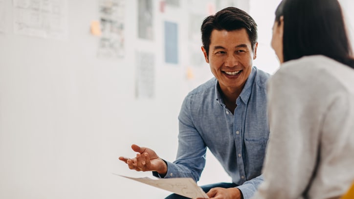 man and woman talking in an office.