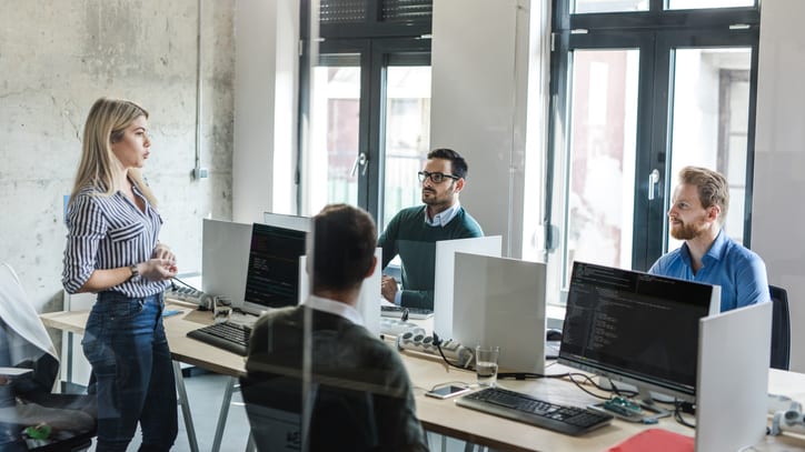 A group of people in an office working on computers.