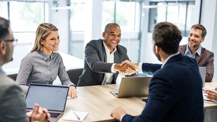 A group of business people shaking hands during a meeting.