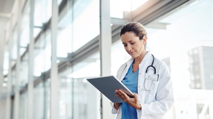 A female doctor using a tablet in an office.