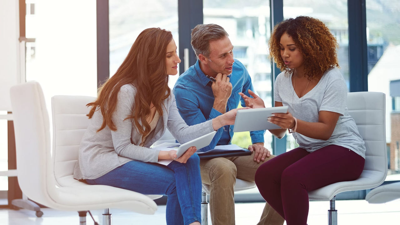 A group of people sitting around a table in an office.