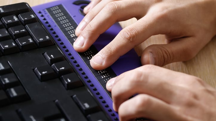 A person is typing on a purple keyboard.