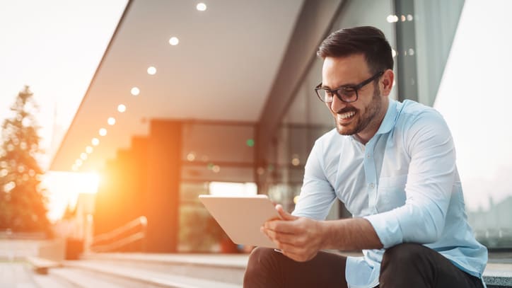 A man sitting on steps with his tablet.