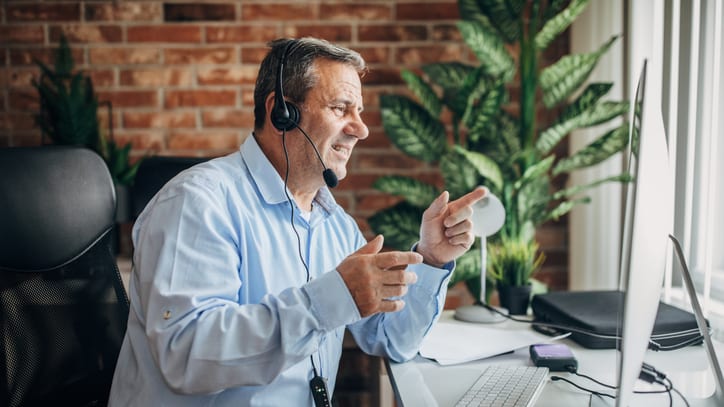 A man wearing a headset in front of a computer.