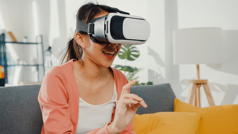 A woman wearing a vr headset while sitting on a couch.