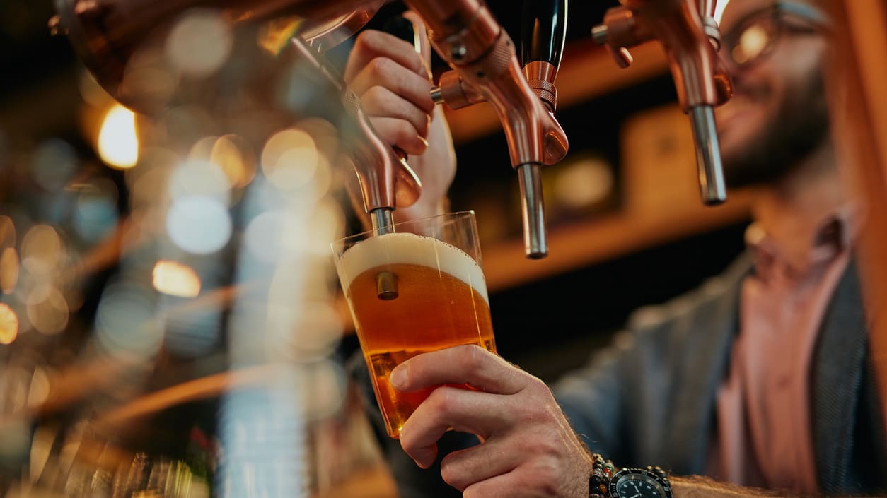 A man pouring a beer into a glass.