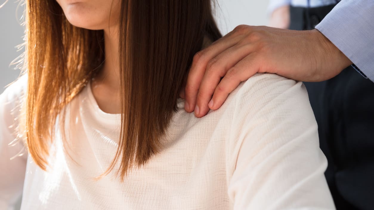 A woman's back is being touched by a man.